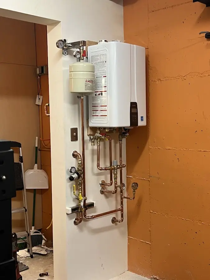 Plumbing technician inspecting water heater connections in Buford